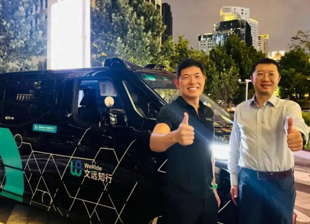 Grab联合创始人兼集团CEO陈炳耀与文远知行创始人兼CEO韩旭在文远知行Robotaxi GXR前合影，中国上海