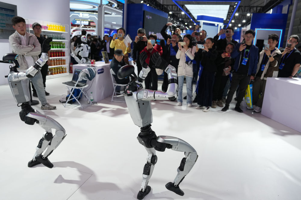 ↑ 11月6日，观众在2025年世界互联网大会“互联网之光”博览会现场观摩人形机器人跳舞。新华社记者 黄宗治 摄