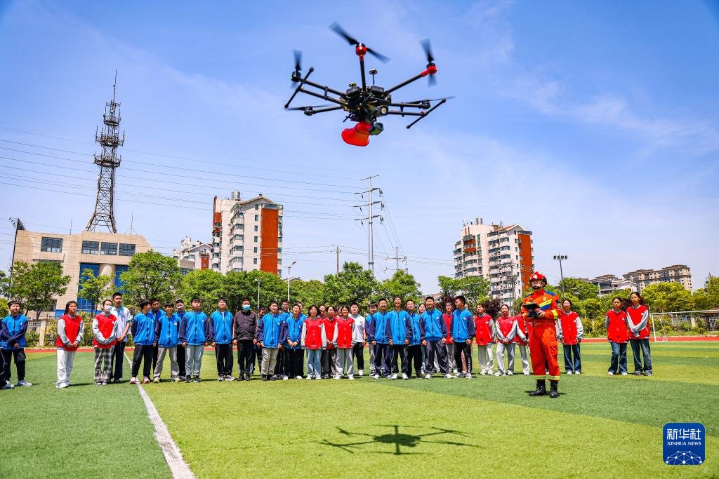 2025年5月12日，扬州市江都区消防救援大队消防员在给中学生演示消防职业技能。新华社发（任飞 摄）