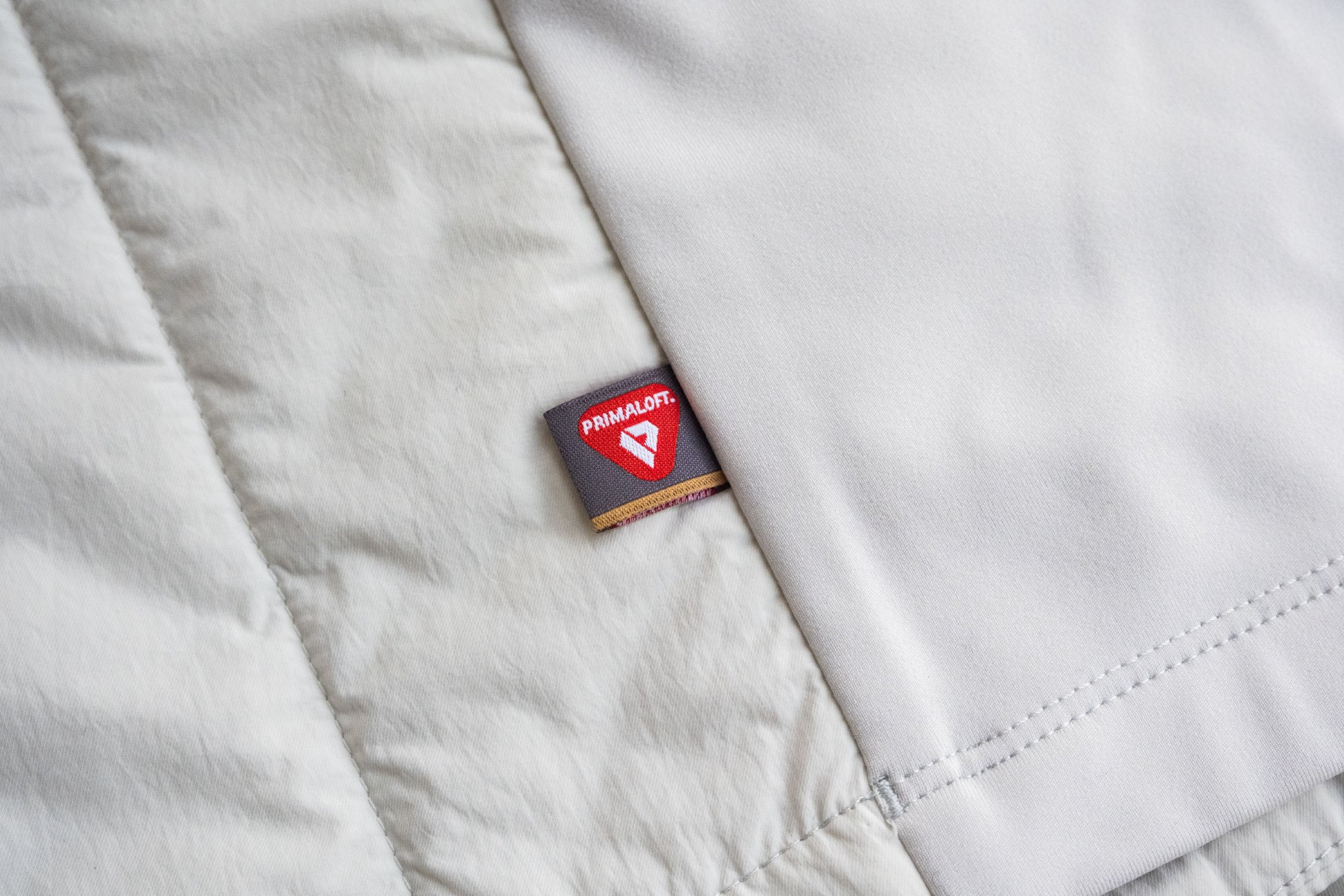 ASICS亚瑟士跑步夹棉夹克上的「金标 P 标」标识 | 图片来源：极客公园