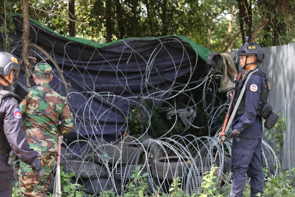 　　8月14日，在柬埔寨班迭棉吉省一個邊境村莊，柬埔寨武裝人員在鐵絲網(wǎng)和輪胎旁執(zhí)勤。新華社/柬新社