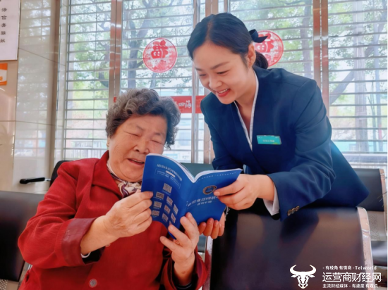 （在中国移动营业厅内，工作人员细心地为老人讲解反诈知识）