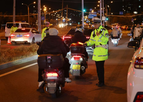 ▲11月12日夜，北京朝阳交通支队机场大队在金盏地区开展酒驾夜查，电动自行车骑行者接受酒驾检测。新京报记者 王贵彬 摄