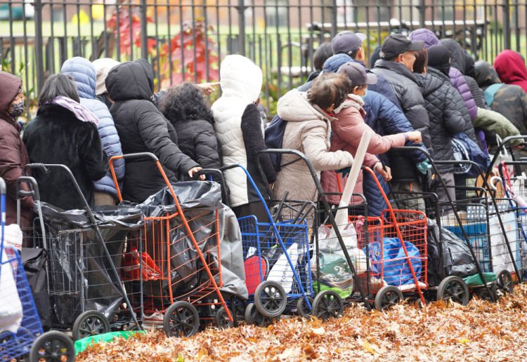 11月12日，人們在美國紐約一處食物發(fā)放點(diǎn)等待領(lǐng)取食物。新華社記者張鳳國攝
