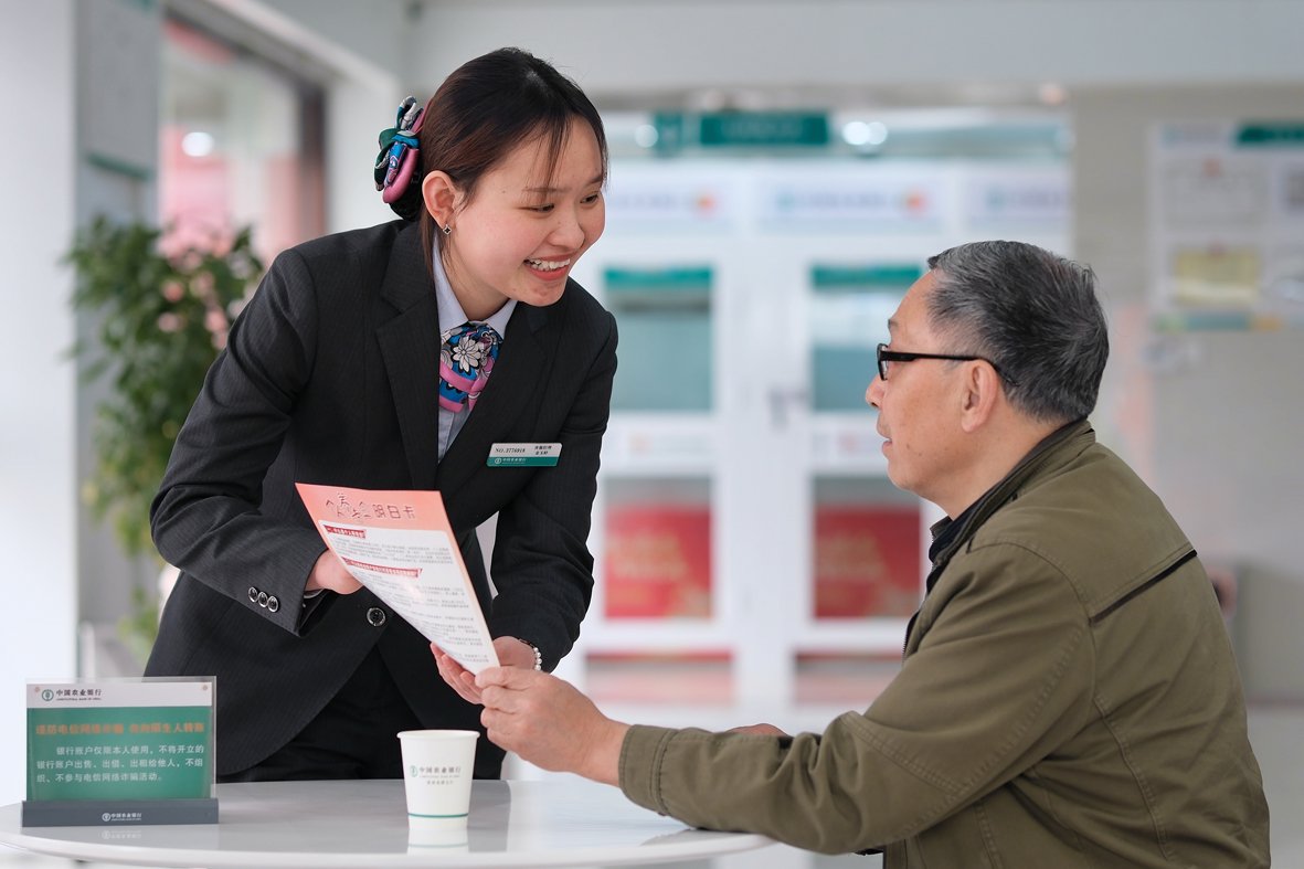 图为农行安徽淮南龙湖支行营业室员工为老年客户介绍养老金融知识。（资料照片）