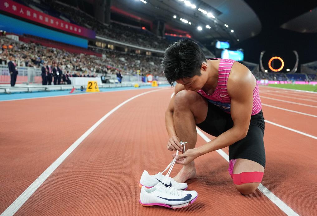 2025年11月20日，苏炳添在第十五届全国运动会田径男子4X100米接力决赛后脱下跑鞋。新华社记者 江汉 摄