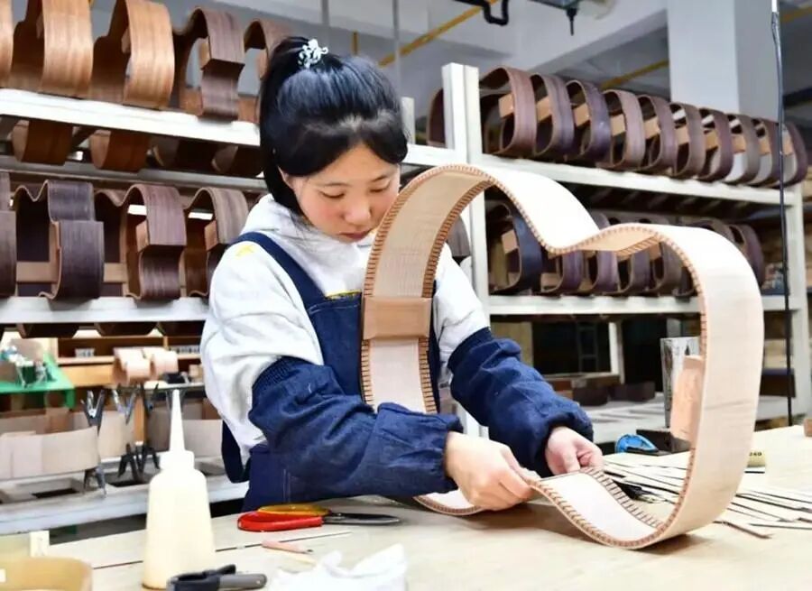 图为桐馨乐器的匠人在制作吉他。