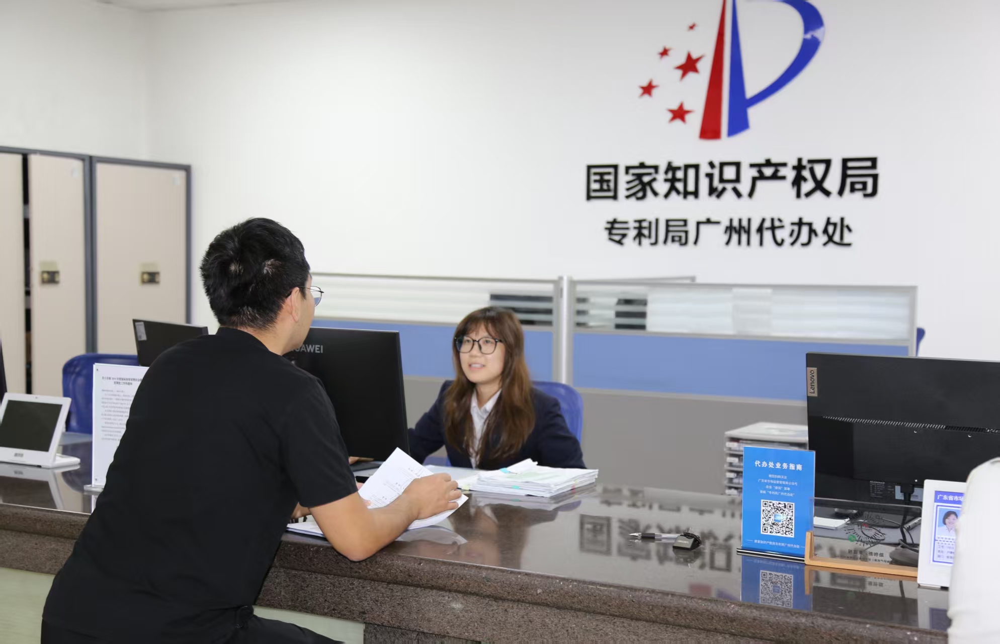　　广州代办处窗口工作人员热情耐心为办事群众解答专利申请相关问题。资料图