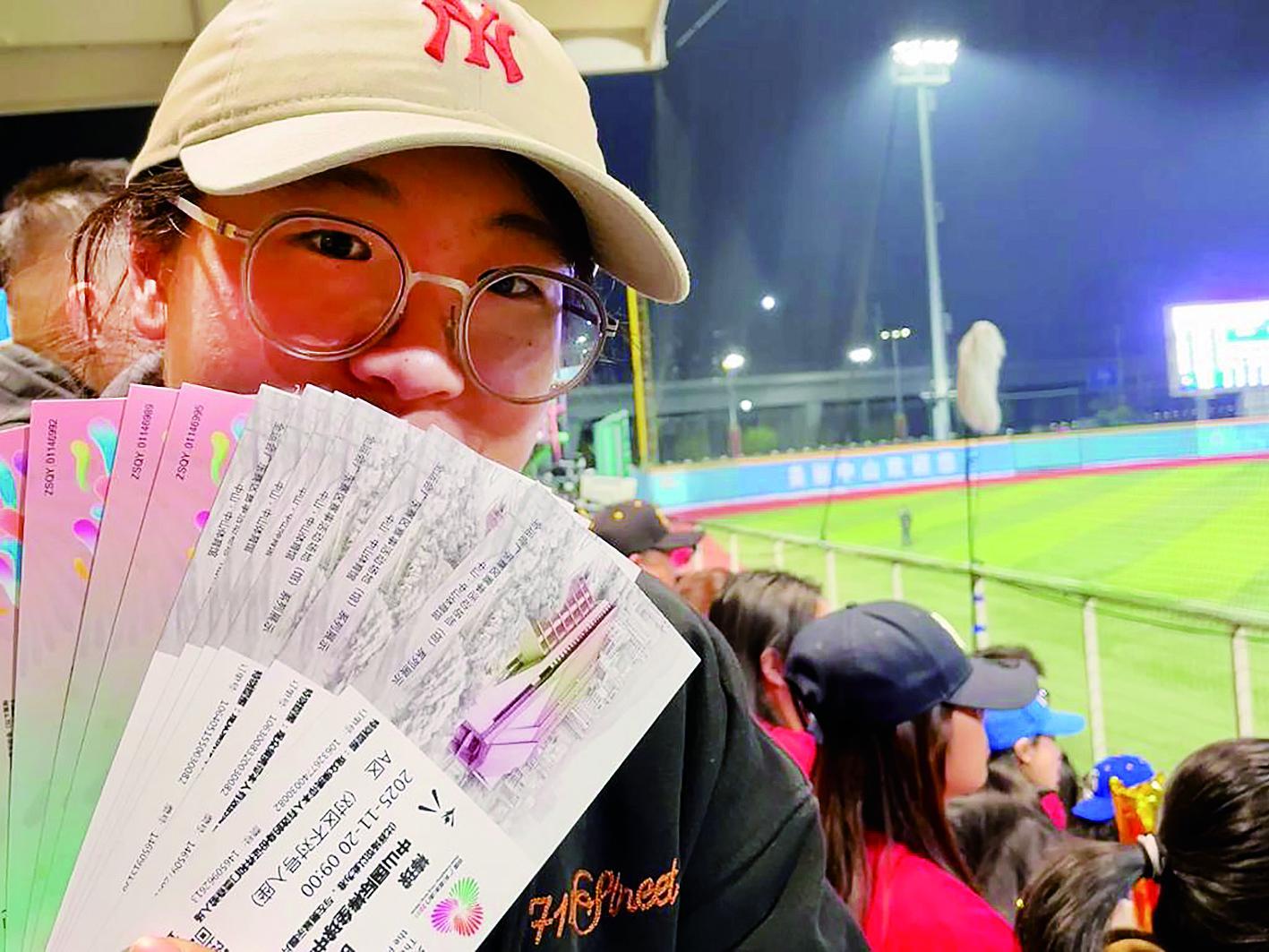 11月20日，一名观众在全运会棒球比赛现场展示自己的票根。 新华社发