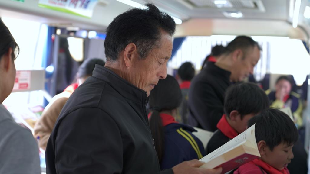 11月11日，河南许昌禹州市方山镇杏山坡村村民在流动图书服务车看书。新华社发（王永涛 摄）