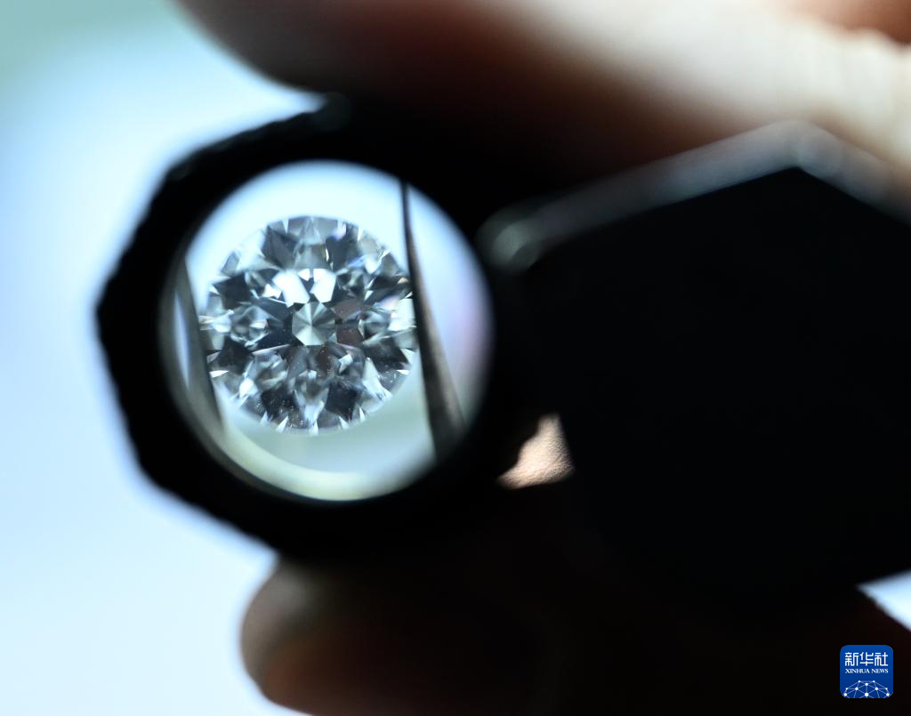 河南省力量钻石股份有限公司工人在查看钻石打磨效果（6月11日摄）。新华社记者 李嘉南 摄