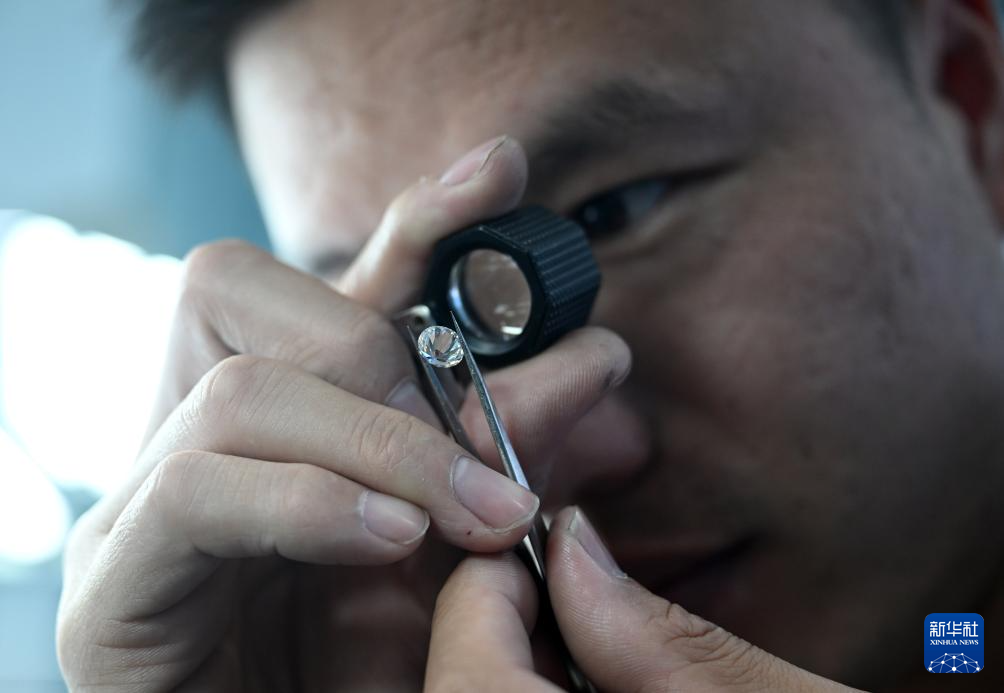 河南省力量钻石股份有限公司工人在查看钻石打磨效果（6月11日摄）。新华社记者 李嘉南 摄