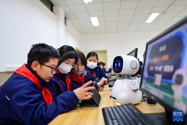 12月5日，杭州市钱塘区学林小学的学生在人工智能通识课上对人工智能机器人进行编程。新华社记者 江汉 摄