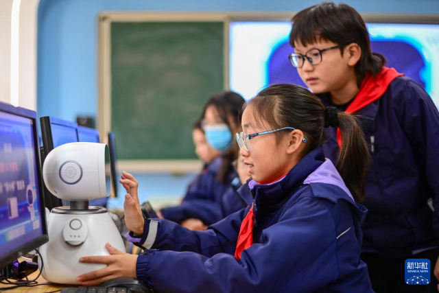 12月5日，杭州市钱塘区学林小学的学生在人工智能通识课上对人工智能机器人进行编程。新华社记者 江汉 摄