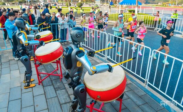 光谷马拉松现场，人形机器人为选手加油（央广网发 光谷马拉松组委会供图）
