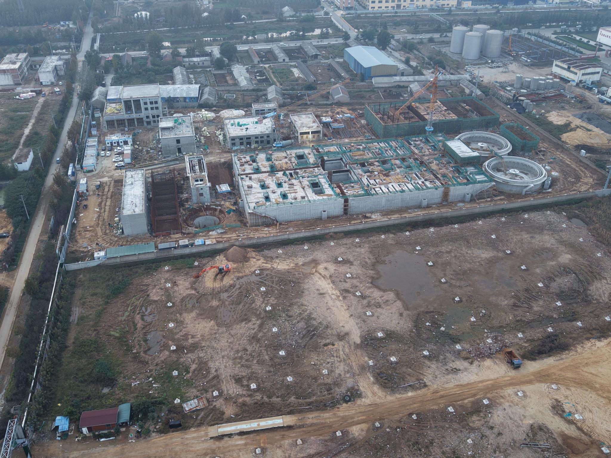 临沭污水处理厂改造被指先建后招:2亿民生工程合规性受质疑(图1) 山东省临沭县牛腿沟污水处理厂提标改造项目虽仍处招投标阶段,现场已是一片忙碌,数十名工人正进行吊装等作业。