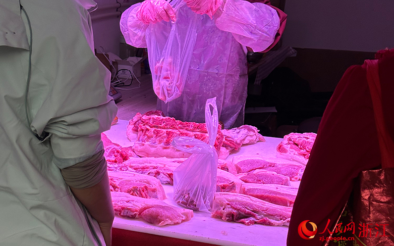 ▲11月8日，杭州市上城区杨柳郡园四区沿街一家“农家土猪肉”店内透出紫红色灯光。图/人民网