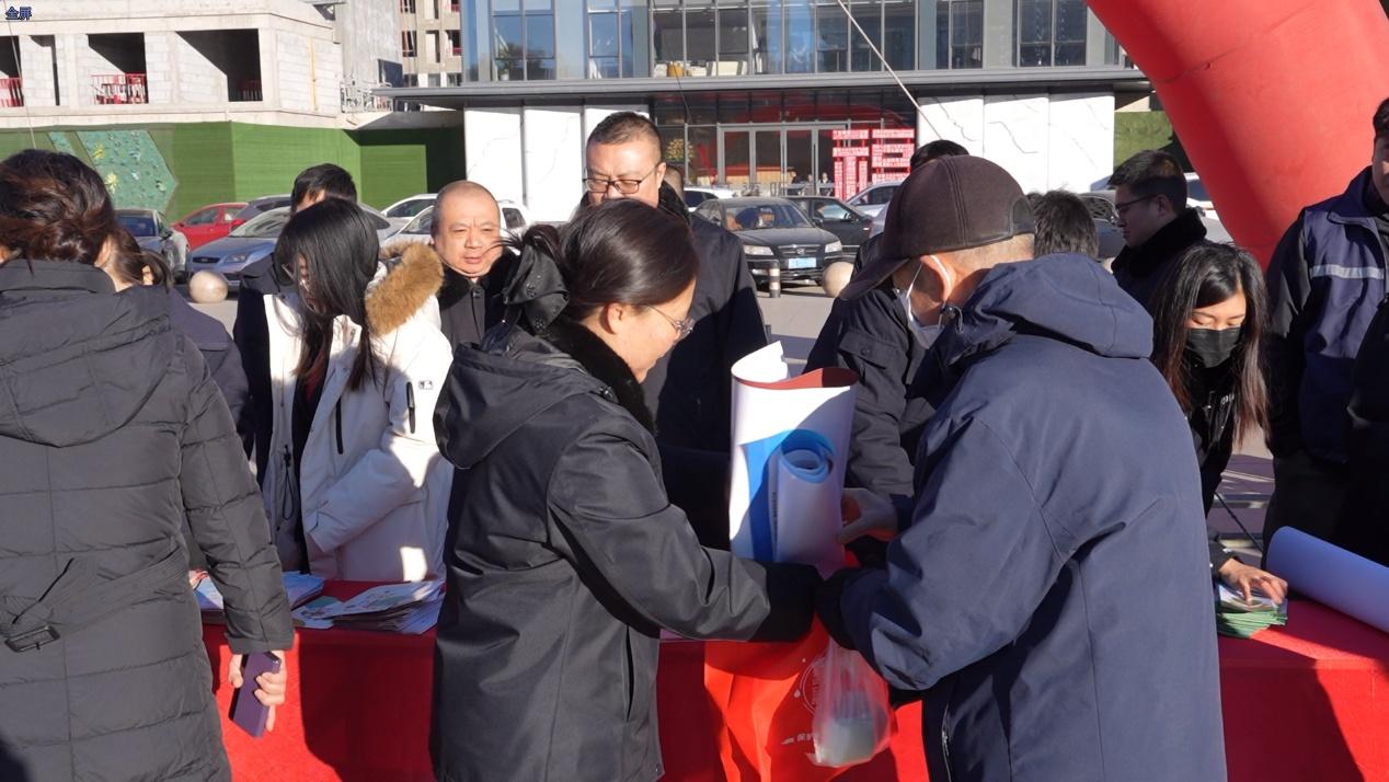 现场工作人员热情地向群众介绍智慧普法平台的使用方法。 王意天摄