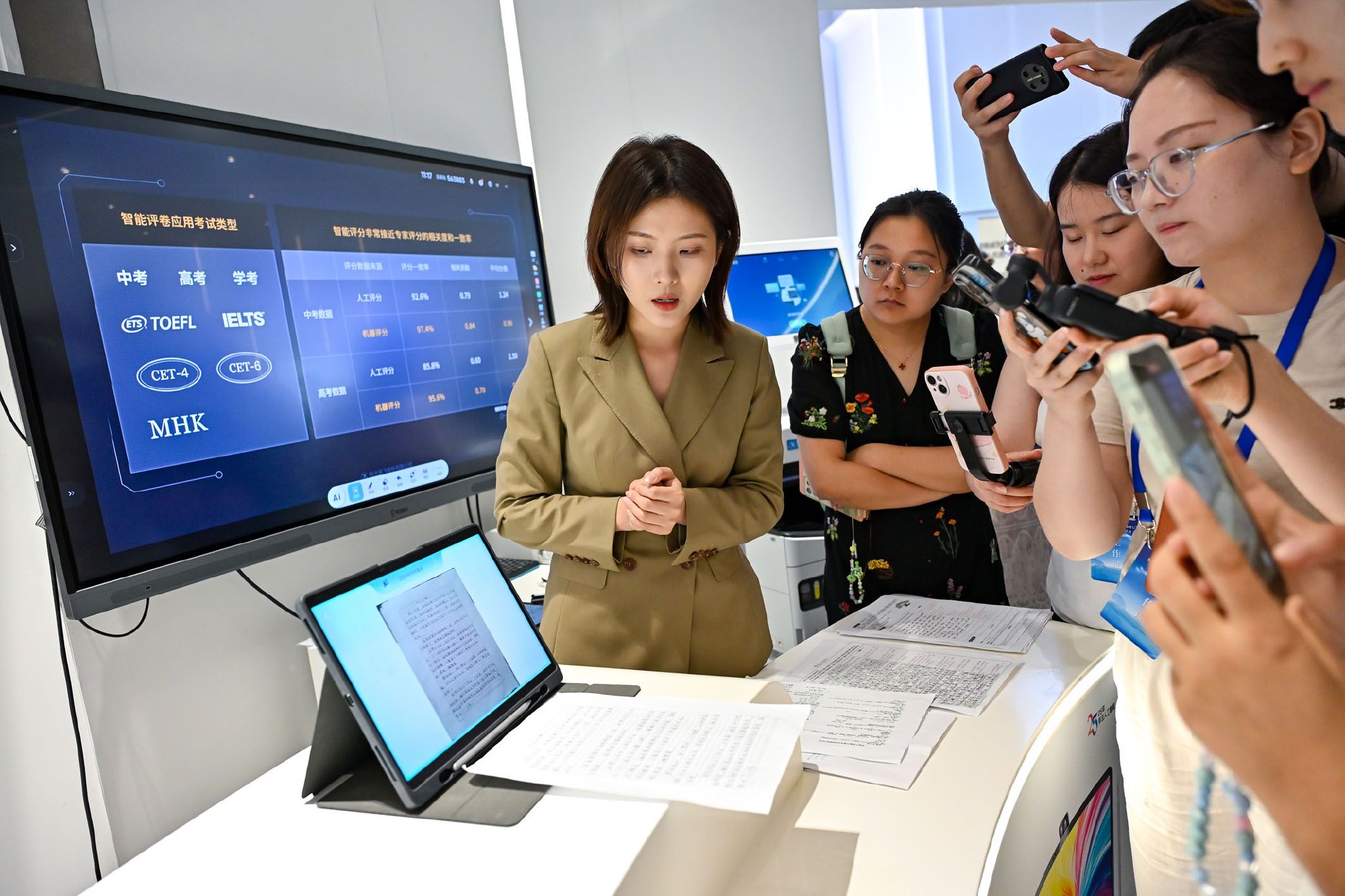 一名工作人员在科大讯飞人工智能体验馆介绍AI学习机的批改作业功能。新华社记者　张铖　摄