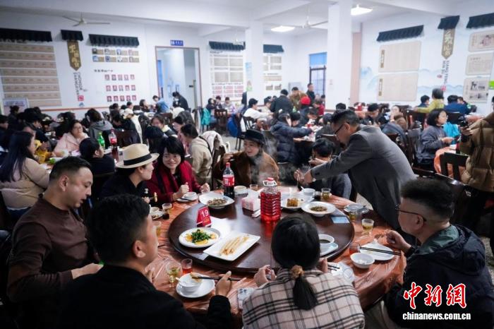 浙江湖州，村民、游客在茅坞村共享年猪饭。湖州市新闻传媒中心供图