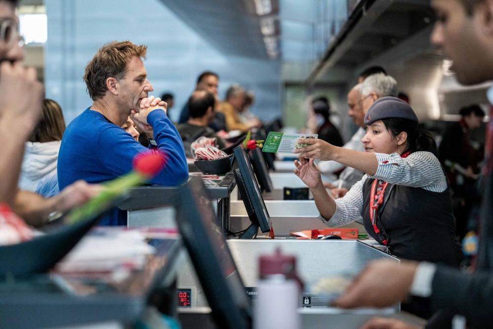 12月20日，旅客在美国旧金山国际机场办理值机手续。新华社发（朱子于 摄）