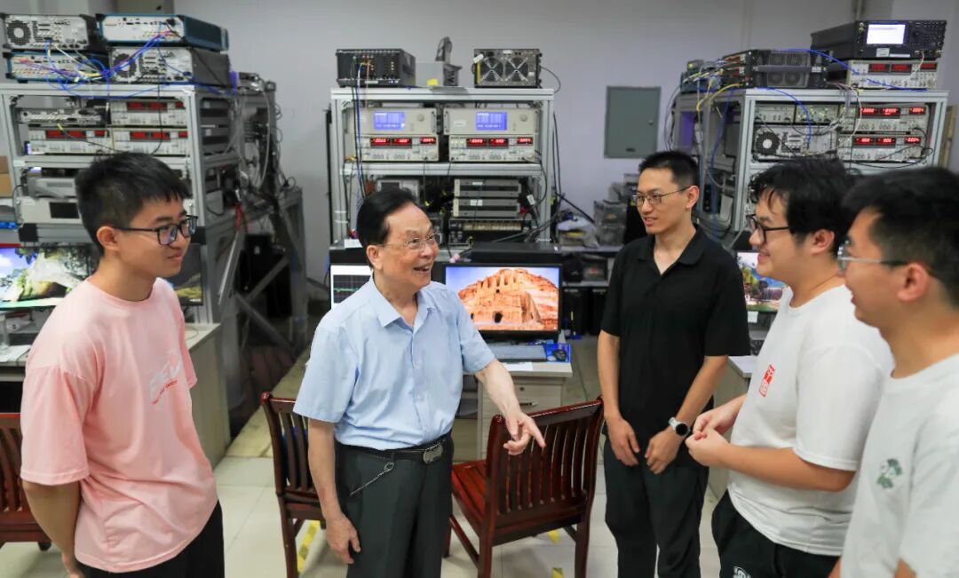 ​郭光灿院士（左二）在实验室和研究团队进行学术交流。季春红 摄