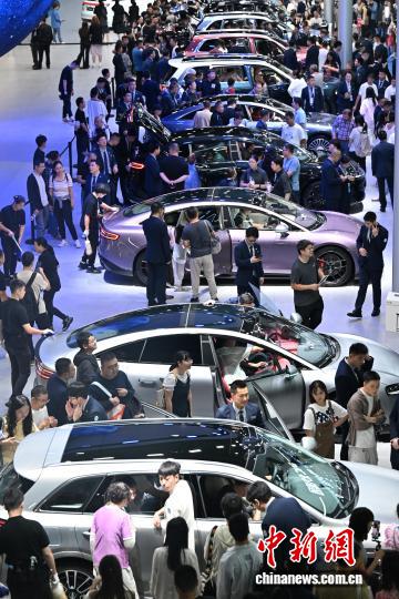  图为第二十八届成都国际汽车展览会期间，国产新能源汽车展台人气旺。　记者 张浪 摄