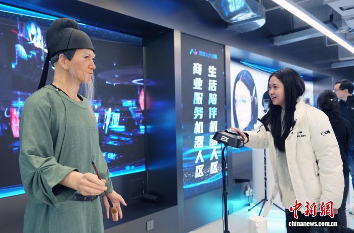  图为参观者在成都“机器人大世界”与仿生人形机器人“杜甫”互动。　记者 安源 摄