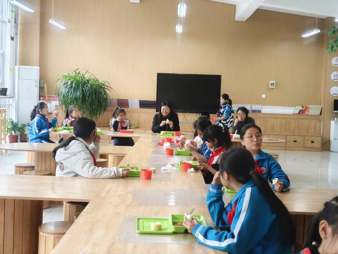 在复兴区实验小学，校长和孩子们一同享用热气腾腾的午餐。