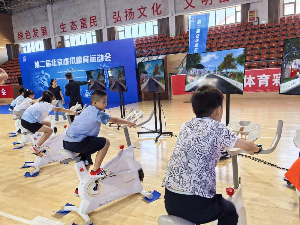 图为在第二届北京虚拟体育运动会上，参赛选手借助“AI+体育”设备进行骑行比赛。
