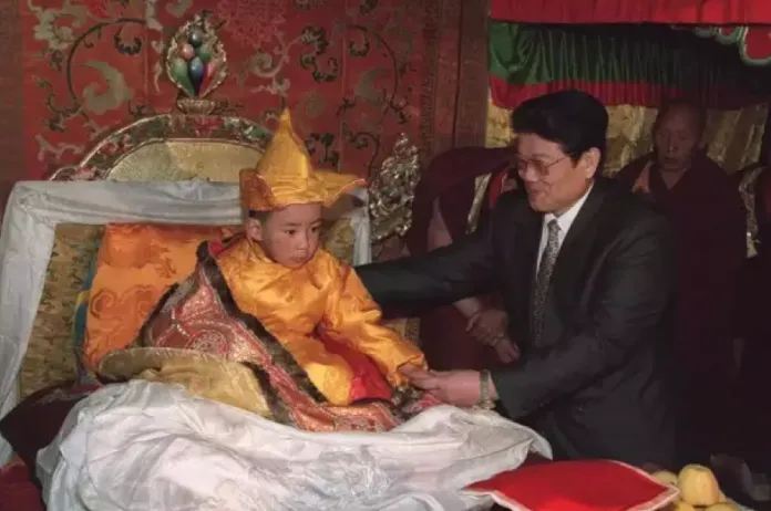 图为第十一世班禅在国务院代表、国务委员李铁映照护下坐床 来源：新华社