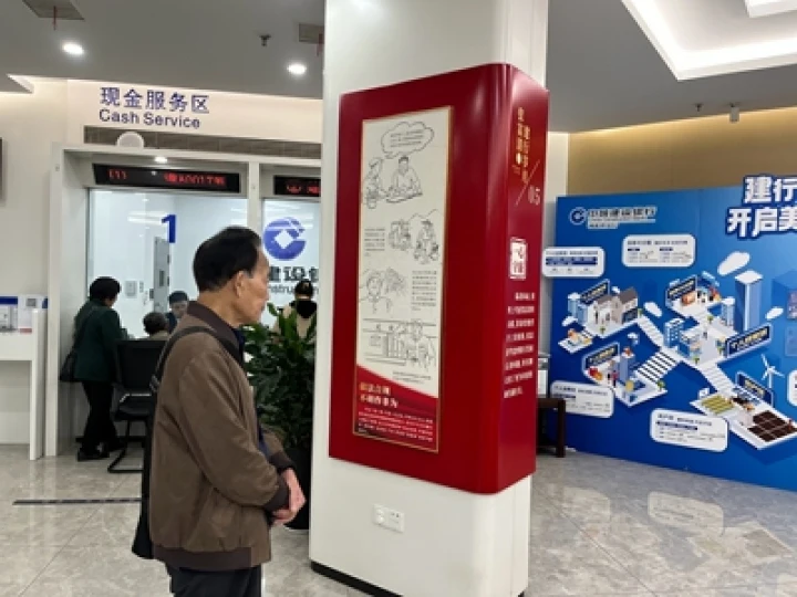 ▲建行湖北恩施来凤支行在营业室墙上张贴张富清老英雄先进事迹，吸引客户驻足观看