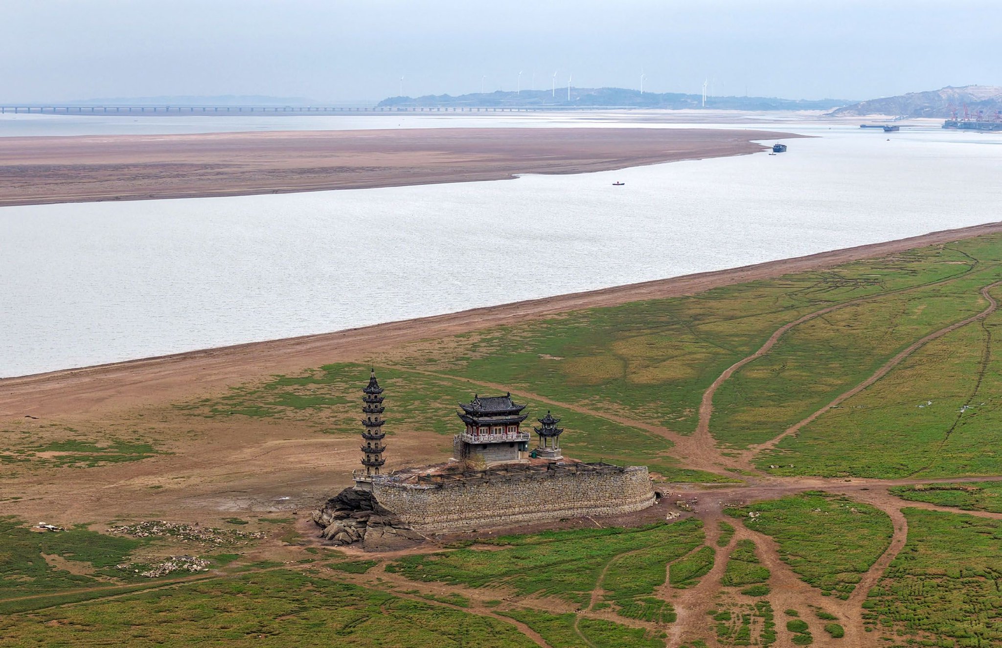 鄱阳湖水位下降，湖区的千年石岛落星墩完全展露出来（2025年12月13日摄，无人机照片）。新华社发（韩俊烜　摄）