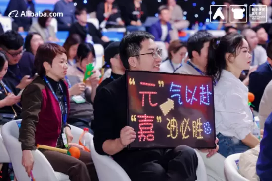 上图为：后援团举出“元气以赴，嘉油必胜”的牌子为杨元嘉加油鼓劲