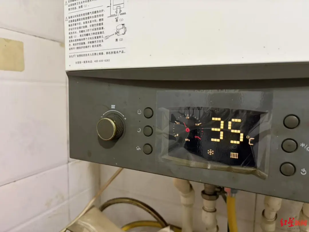 ▲有村民将燃气炉调至低温运行状态 付垚/摄