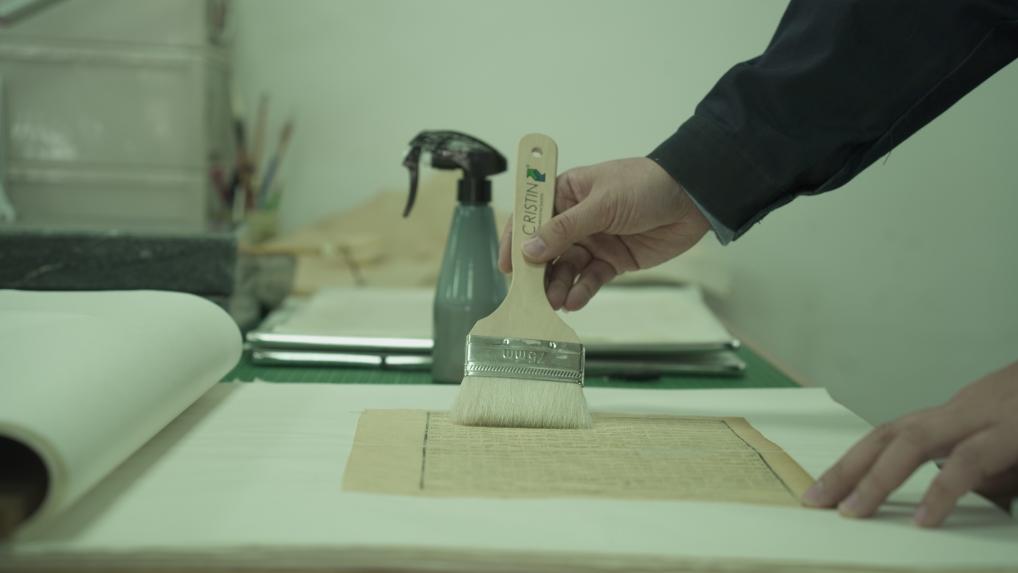 　　古籍修复师王泓杰正在将修复后的古籍书叶喷水压平。新华社记者 包庆龄 摄