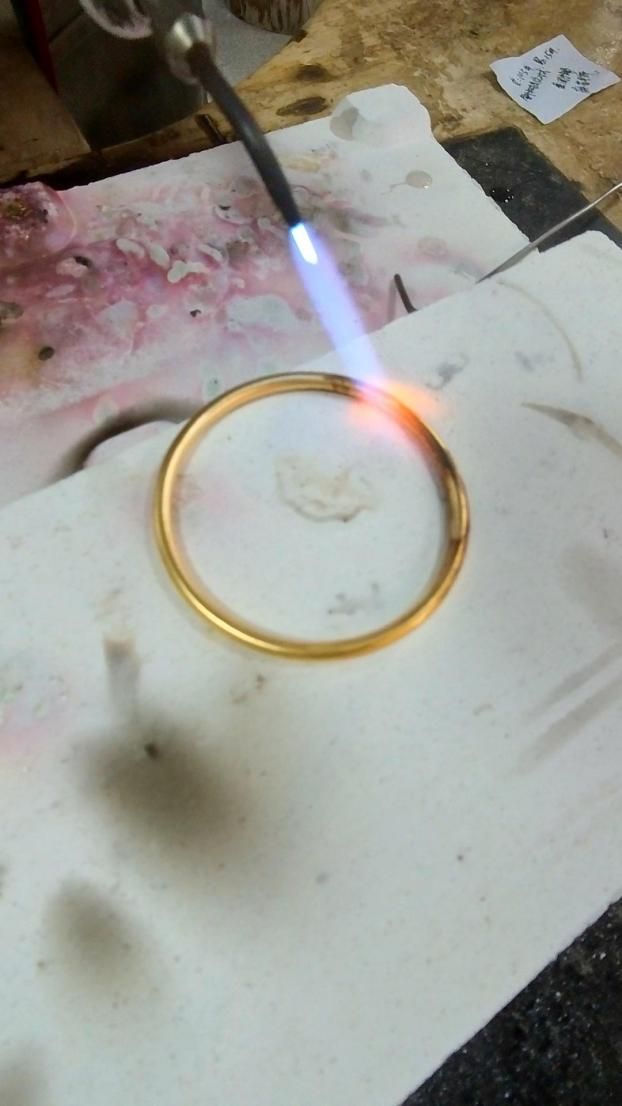 图为黄金手镯抹了洗洁精后，在硬火灼烧下会变黑。