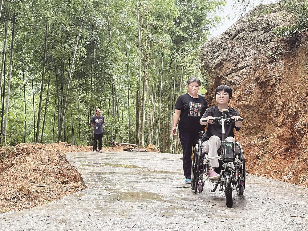 陈春花坐着轮椅行驶在“爱心路”回家。（受访者供图）