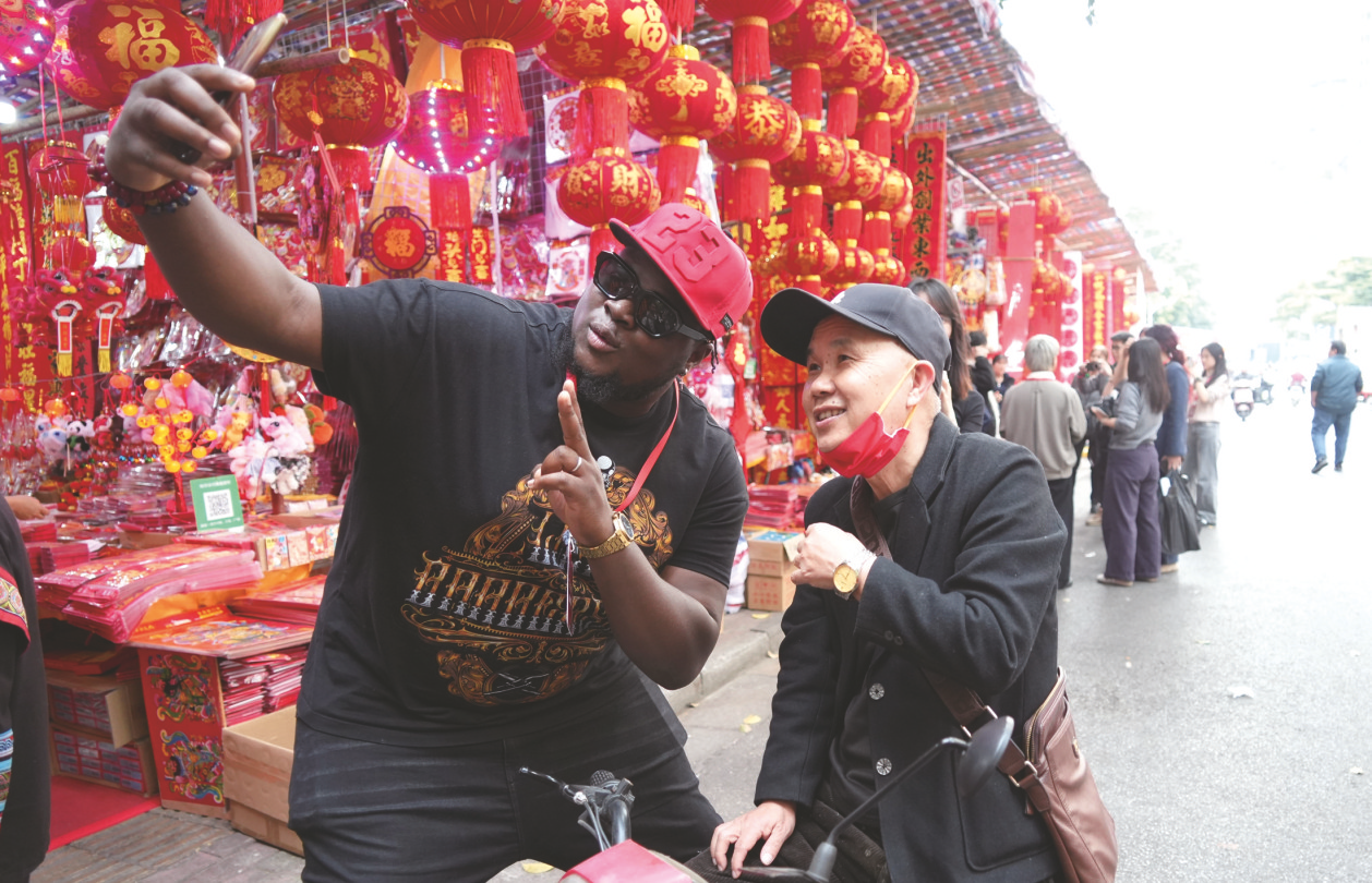     小黑（拉堡仔）和市民合影互动。本报记者宋延康 摄