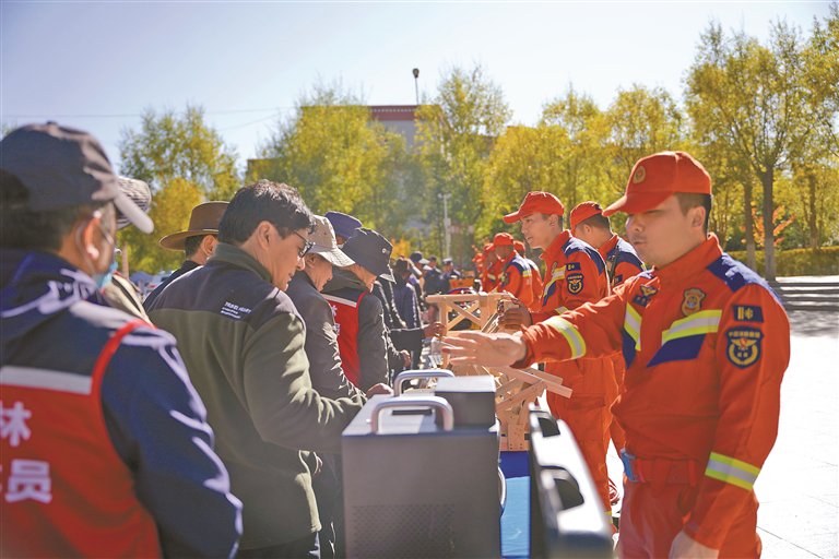 图为宣传员为群众讲解各类装备的用途与操作原理。记者　余书冉　摄