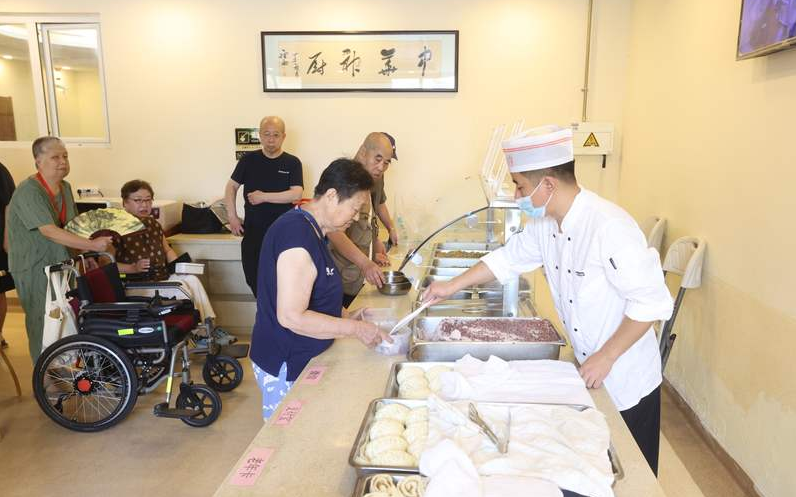 ▲北京大兴区亦庄镇区域养老服务中心，老年人在排队打饭。新京报记者 王贵彬 摄