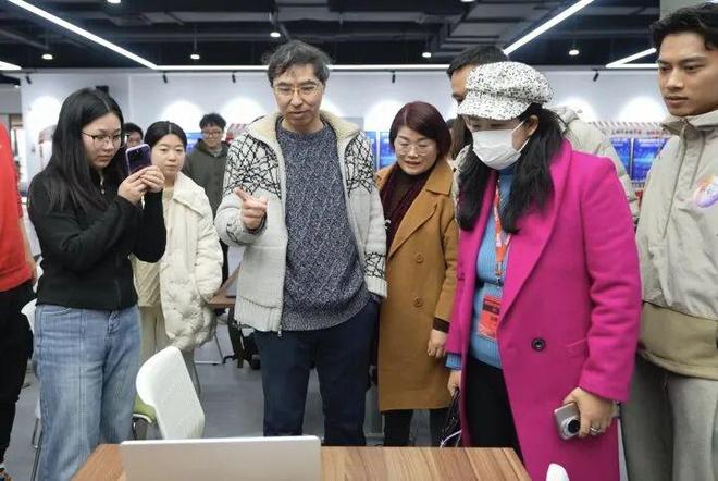 图为灵光AI智媒中心首席工程师高晓演示“手势送福”，吸引了很多人围观