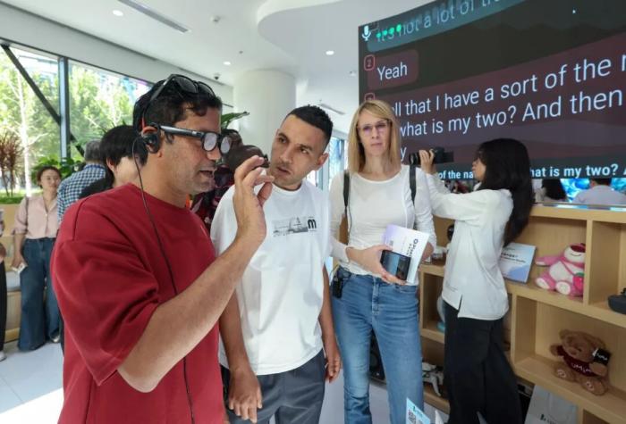 2025年9月29日，在“外国记者走进北京”——经开区专题推介活动上，外国记者佩戴自动翻译眼镜。中新社记者 贾天勇 摄