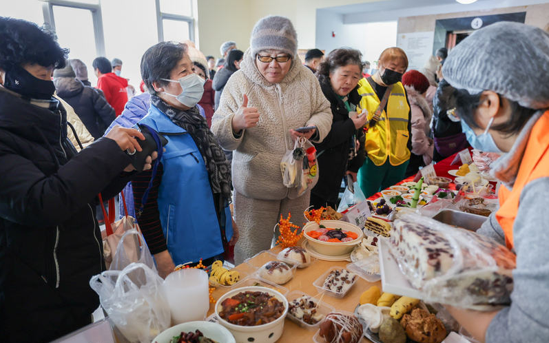 ▲在北京东城区社区服务中心，市民为志愿者和现场的养老助餐机构点赞。 新京报记者 王子诚 摄