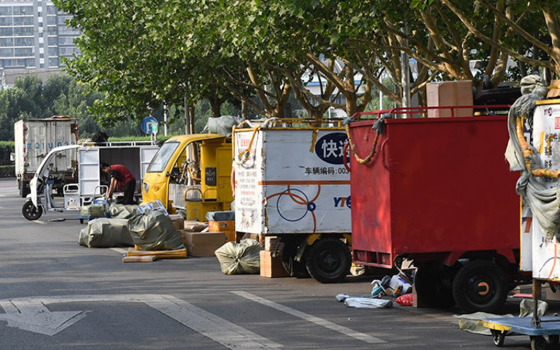 ▲路边停满了快递三轮车。图/新京报资料图