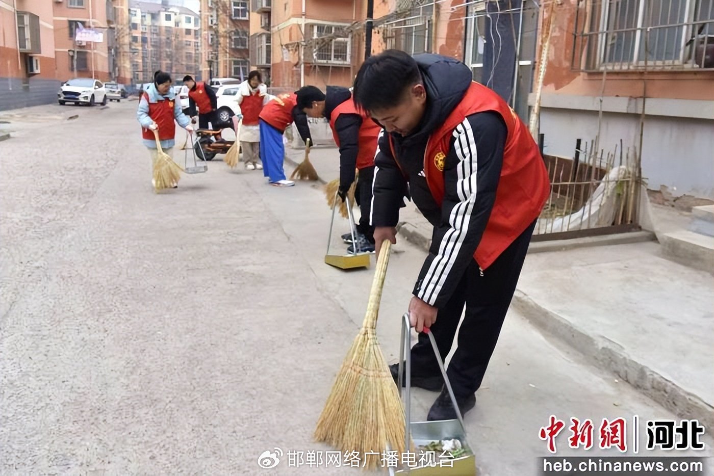 图为大学生志愿者在小区内清理垃圾。 陈虎斌 摄