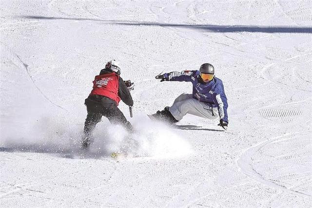在位于河北崇礼的国家跳台滑雪中心，滑雪摄影师张续威（左）在拍摄。光明图片