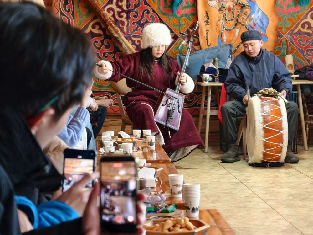 　　1月30日，台湾青年在新疆喀纳斯景区的木屋欣赏蒙古族图瓦人演奏。新华社记者 贺小童 摄