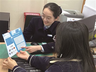 　　建行温州鹿城支行工作人员为市民介绍并办理外汇兑换业务。 李小洁 摄