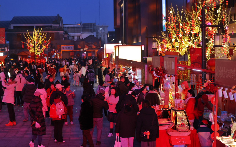 ▲北京隆福寺新春市集灯光五彩缤纷，市民游客络绎不绝。新京报记者 王贵彬 摄